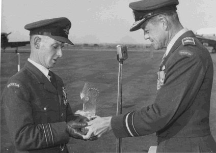 Sqn Ldr "Ozzie" Penton receives the Jacklin Trophy from AVM RAF Bentley on behalf of No 7 Sqn. (1964)